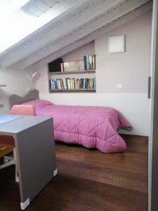 a bedroom with a pink bed and a book shelf at Casa in residence - Padenghe sul Garda in Padenghe sul Garda