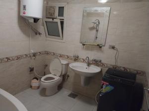 uma casa de banho com um WC e um lavatório em Compound city towers em Cairo
