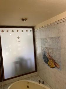 baño con bañera y una pintura en la pared en La casa de los murales en Córdoba