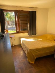 a bedroom with a bed and a window and a table at La casa de los murales in Cordoba