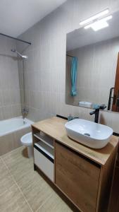 ein Badezimmer mit einem Waschbecken, einem WC und einem Spiegel in der Unterkunft Puipana Apartment, Fuerteventura in Puerto del Rosario