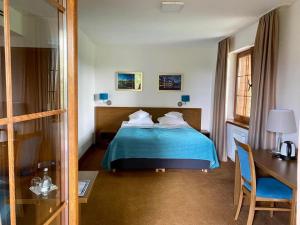 a hotel room with a bed with a blue blanket at HOTEL CICHA WODA NIEPORĘT in Nieporęt