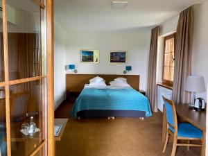 HOTEL CICHA WODA NIEPORĘT في نيبورت: غرفة فندق بسرير وبطانية زرقاء