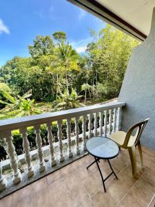 a balcony with a table and a chair at Ngermid Oasis Large Studio With Kitchen & Scenic Views in Koror