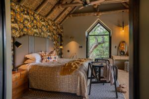 荊棘叢禁獵區的住宿－荊棘叢遊戲山林小屋，一间卧室配有一张床、一张桌子和一个窗户。