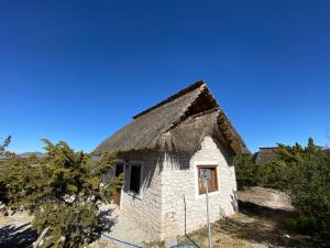 een oud stenen huis met een rieten dak bij Ecoturismo Cabañas La Florida in Cardonal