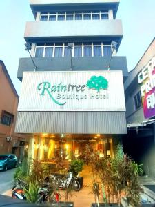 a restaurant with a sign on the front of a building at Raintree Boutique Hotel in Kajang