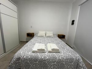 a bedroom with a bed with two towels on it at Departamento Hilario in San Rafael