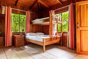 1 dormitorio con literas en una casa de madera en Whale Tail Hotel en Uvita