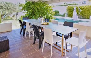 - une table et des chaises sur une terrasse avec piscine dans l'établissement 3 Bedroom Amazing Home In Rochefort, à Rochefort-du-Gard