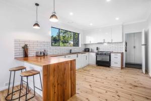 a kitchen with white cabinets and a wooden counter top at Scenic Stay I Short or Long Term in Geelong