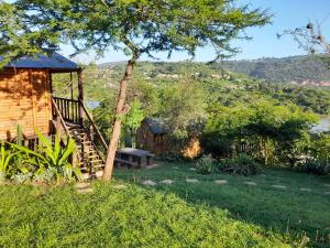 a house with a staircase next to a tree at Entendeni Lodge SelfCatering in Inanda +28 photos