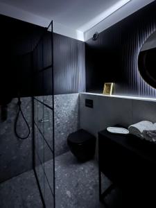 a black bathroom with a toilet and a sink at C53 in Warsaw