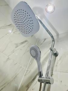 a shower with a shower head in a bathroom at Beautiful and Homely 3 Bed House With FREE Parking So Close To Man City and City Centre in Manchester