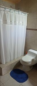 a bathroom with a white shower curtain and a toilet at Casa de campo Aires de Curacaví in Curacaví