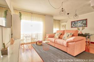 a living room with a pink couch and a window at Walker Apartamento Centro Murcia con parking privado in Murcia