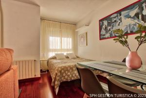 a hotel room with a bed and a table with chairs at Walker Apartamento Centro Murcia con parking privado in Murcia