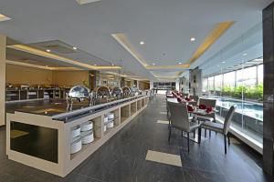 un ristorante con bar con sedie e tavoli di Serela Waringin by KAGUM Hotels a Bandung