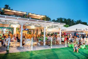 a crowd of people sitting on a deck at a restaurant at Maszoperia Sun4hel Kite & Wind & Surf in Jastarnia