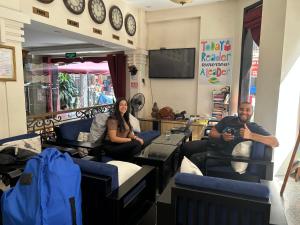 un homme et une femme assis sur des chaises dans une pièce dans l'établissement Hạ Long Starlight Hotel, à Hạ Long