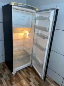 an empty refrigerator with its door open in a kitchen at Apartamento do Walisson in Guaramiranga