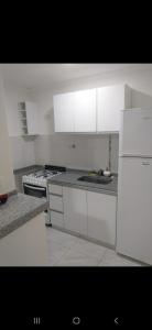 een keuken met witte kasten en een witte koelkast bij Departamento 51 TORRE PARIS in Resistencia