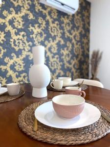 a wooden table with a bowl and cups on it at Villa Contemporaine in Châtellerault