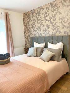 a bedroom with a large bed with many pillows at Villa Contemporaine in Châtellerault