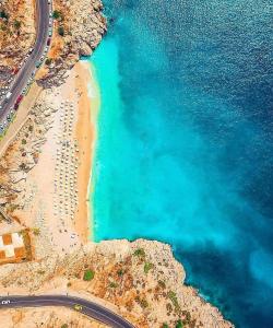 eine Luftansicht auf einen Strand mit blauem Wasser in der Unterkunft Havuzu dışarıdan görünmeyen jakuzili özel havuzlu lüks villa in Kalkan