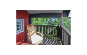 a chair sitting on the porch of a red house at Awesome Home In Dals Lnged With House Sea View in Dals Långed