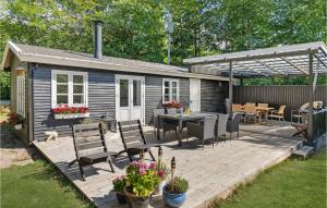 a house with a deck with a table and chairs at 2 Bedroom Lovely Home In Rnne in Rønne