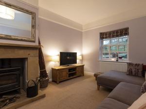 a living room with a fireplace and a television at Ivy Cottage in Grosmont