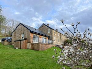 a large wooden house on a grassy field at Ivy Cottage in Grosmont