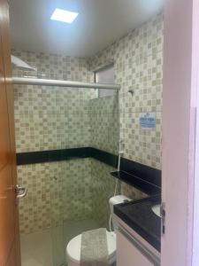 La salle de bains est pourvue de toilettes et d'une douche en verre. dans l'établissement Praia dos carneiros flat hotel, à Tamandaré