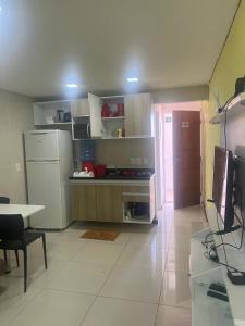 a kitchen with a refrigerator and a table in it at Praia dos carneiros flat hotel in Tamandaré