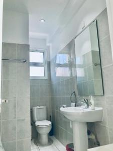 y baño con lavabo, aseo y espejo. en Diana Townhouse 5, en Pafos