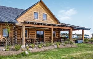 a log cabin with a porch and picnic tables at Nice Apartment In Jezierzany With Kitchen in Jezierzany