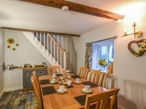 uma sala de jantar com uma mesa de madeira e cadeiras em Bodeinion em Llanfair Caereinion