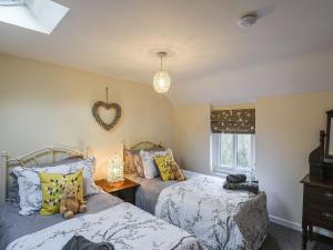 um quarto com 2 camas e uma decoração de coração na parede em Bodeinion em Llanfair Caereinion