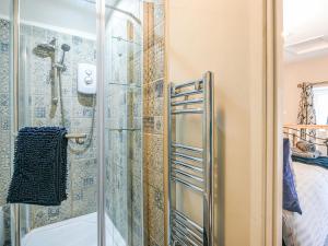 uma casa de banho com um chuveiro e uma porta de vidro em Bodeinion em Llanfair Caereinion