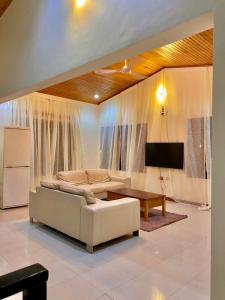 een woonkamer met een witte bank en een tv bij GHouse in Adentan