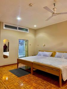 een slaapkamer met een bed en een plafondventilator bij GHouse in Adentan