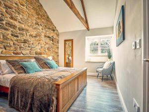a bedroom with a stone wall and a large bed at Hall Yards Cottage in Chesters