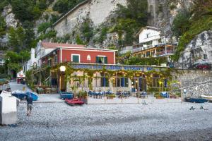 a person standing on a beach in front of a building at Hotel Alfonso A Mare in Praiano