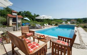 a patio with a table and chairs next to a swimming pool at 4 Bedroom Amazing Home In Suhac in Suhač
