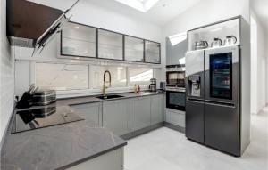 a kitchen with white cabinets and stainless steel appliances at Nice Home In Nexø With Sauna in Neksø