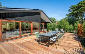 a wooden deck with a table and chairs on it at Nice Home In Nexø With Sauna in Neksø +25 photos