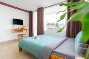 a bedroom with a bed and a large window at RAON Villa - STAY 24H in Da Lat