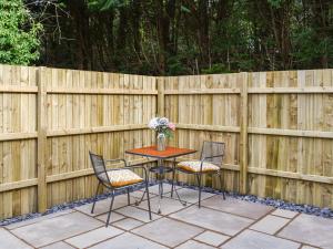 a wooden fence with a table and two chairs at Mattys Place in Nannerch