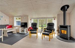 uma sala de estar com um fogão a lenha numa pequena casa em 3 Bedroom Beautiful Home In Lgstr em Løgsted